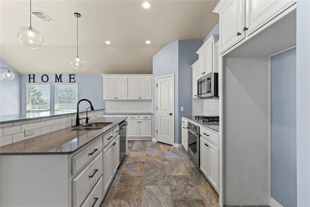 kitchen featuring dark stone countertops, appliances with stainless steel finishes, sink, and white cabinets