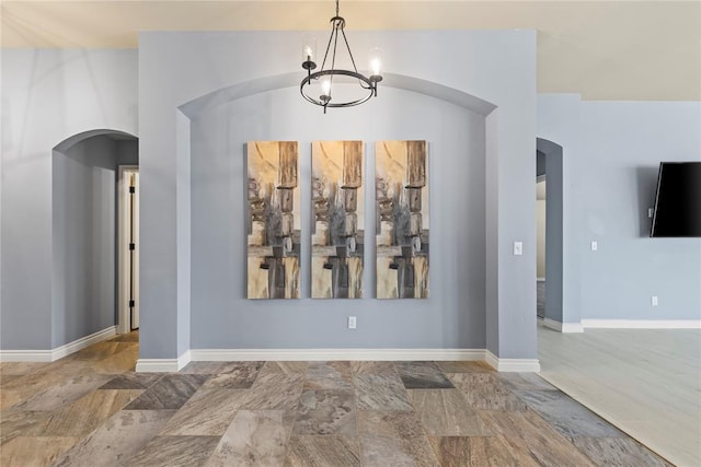 unfurnished dining area featuring a chandelier