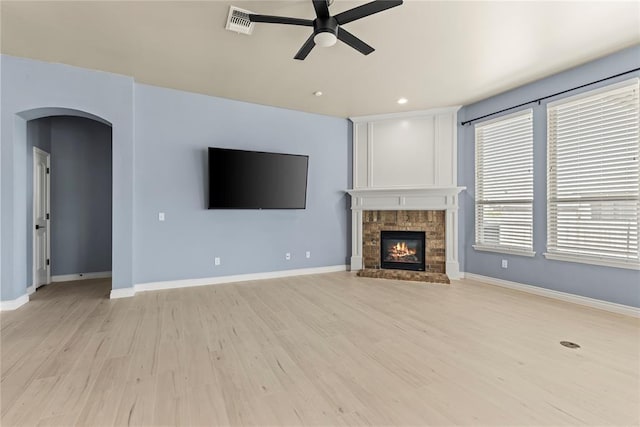 unfurnished living room with a fireplace, light hardwood / wood-style flooring, and ceiling fan