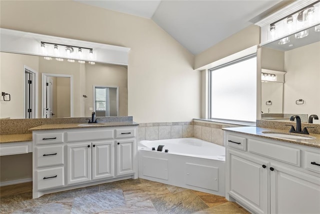 bathroom featuring vanity, lofted ceiling, and a bathtub