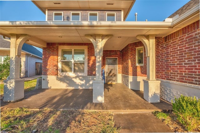 view of exterior entry featuring covered porch