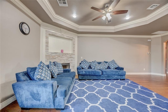 living room with ceiling fan, ornamental molding, a tray ceiling, and hardwood / wood-style floors