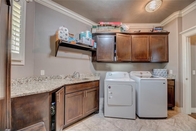 laundry room with crown molding, cabinets, sink, and washing machine and clothes dryer