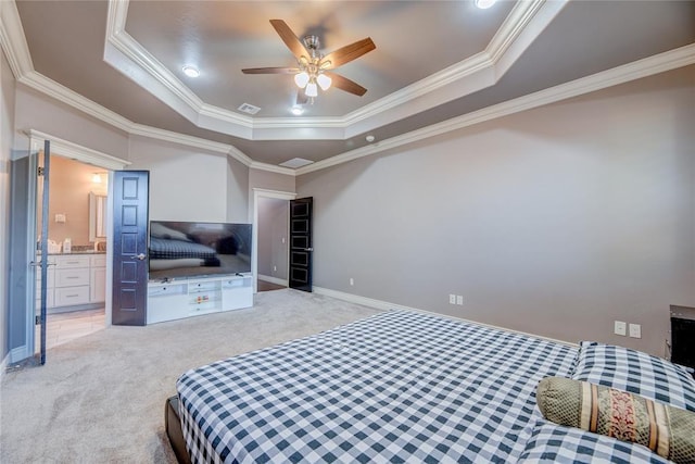 bedroom with connected bathroom, ornamental molding, ceiling fan, a raised ceiling, and light carpet