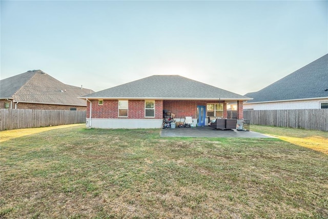 rear view of house featuring a yard and a patio