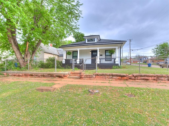 bungalow-style home with covered porch and a front lawn