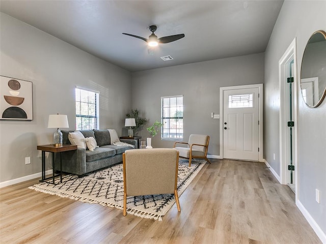 living room with ceiling fan and light hardwood / wood-style flooring