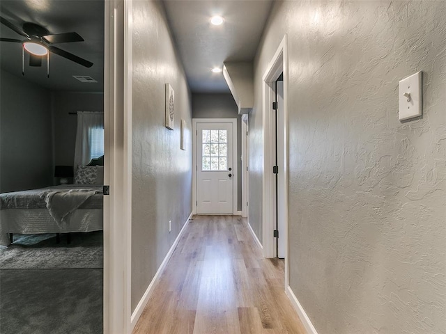 hallway with light hardwood / wood-style flooring