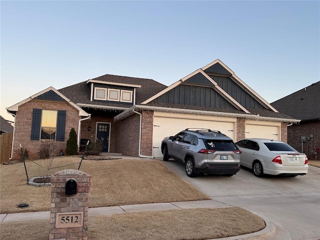 view of front of property featuring brick siding, a shingled roof, concrete driveway, an attached garage, and board and batten siding