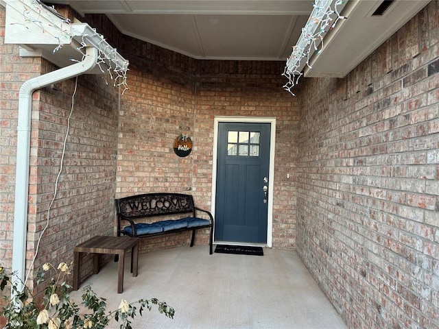 entrance to property featuring brick siding