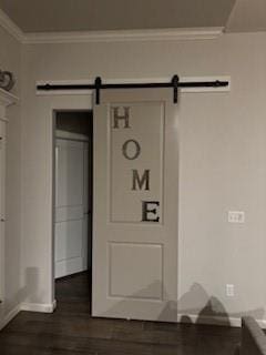 details with crown molding, a barn door, and hardwood / wood-style floors