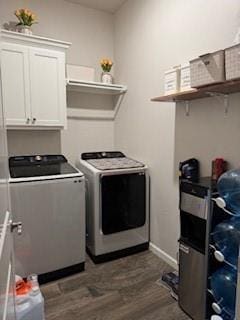 washroom featuring dark wood-style flooring, cabinet space, and washer and clothes dryer