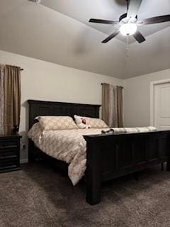 bedroom with vaulted ceiling, dark colored carpet, and a ceiling fan