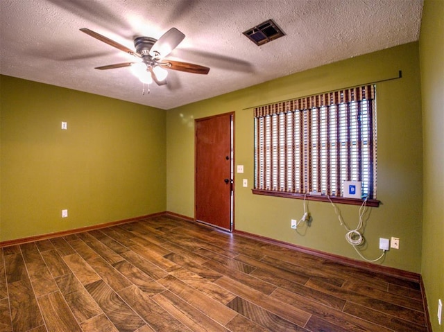 unfurnished room with ceiling fan, dark hardwood / wood-style flooring, and a textured ceiling