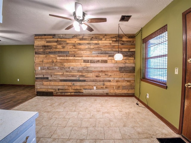 unfurnished dining area with a textured ceiling and ceiling fan