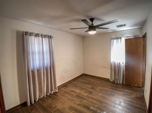 spare room with dark hardwood / wood-style floors and ceiling fan