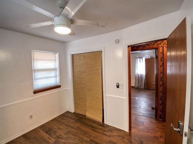 unfurnished bedroom with dark wood-type flooring, a closet, and multiple windows