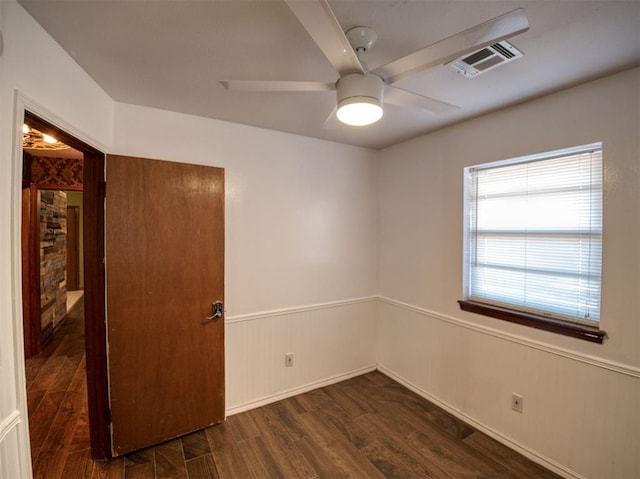 empty room featuring dark wood-type flooring and ceiling fan