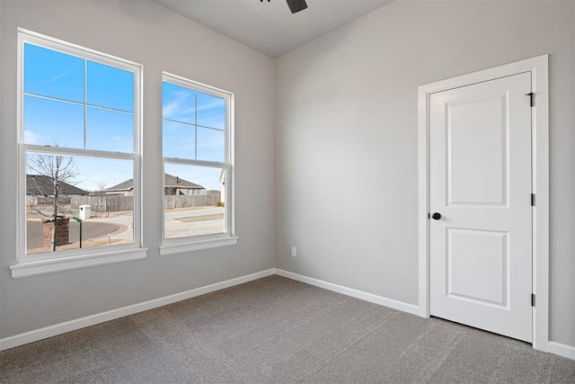 empty room featuring carpet floors, ceiling fan, and baseboards