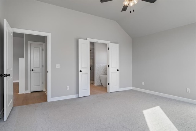 unfurnished bedroom with carpet floors, baseboards, and lofted ceiling