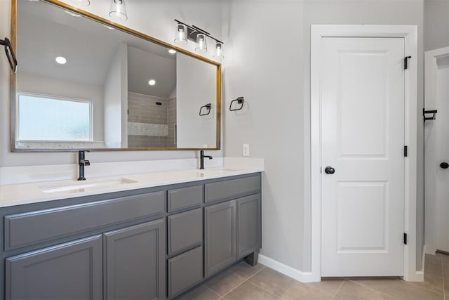 full bathroom featuring tile patterned flooring, a sink, baseboards, and double vanity