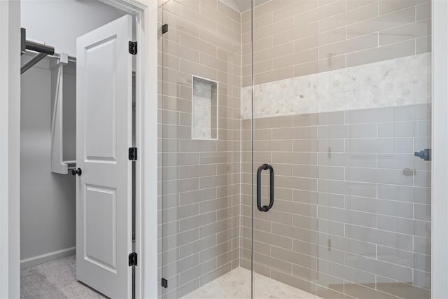 full bath with a shower stall and baseboards