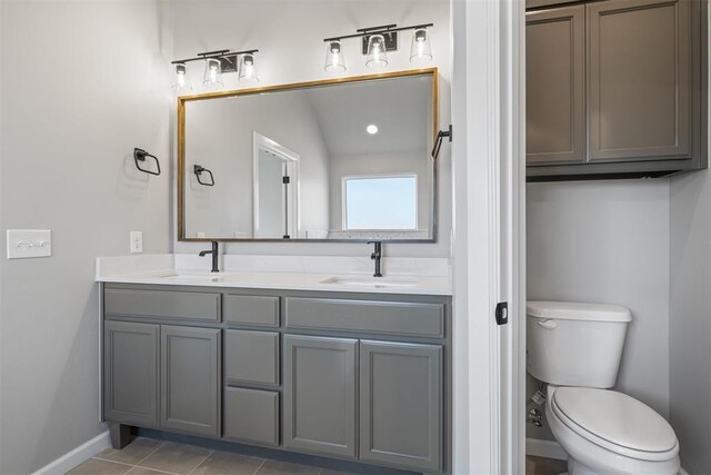 full bathroom featuring double vanity, a sink, toilet, and tile patterned floors