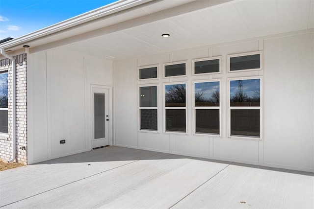 doorway to property featuring brick siding and a patio area