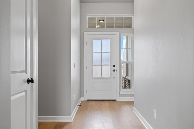 doorway to outside with light wood-style floors and baseboards