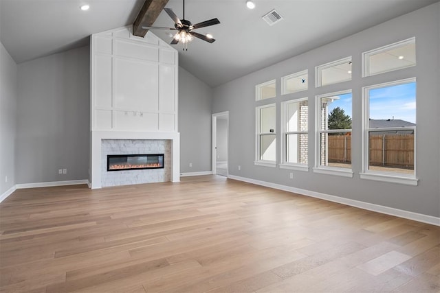 unfurnished living room featuring ceiling fan, light wood-style flooring, a fireplace, visible vents, and beamed ceiling