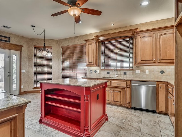 kitchen with sink, hanging light fixtures, light stone counters, a kitchen island, and stainless steel dishwasher