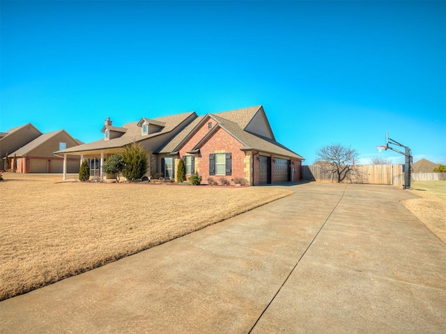 view of front of home with brick siding, a chimney, concrete driveway, fence, and a garage