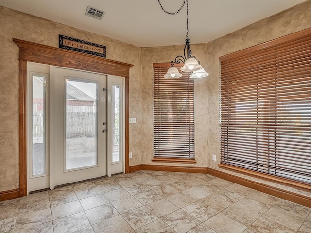 interior space with a wealth of natural light, visible vents, and an inviting chandelier