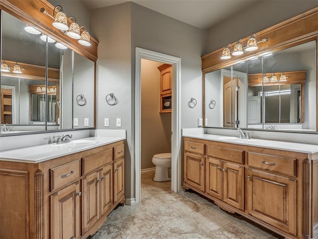 bathroom with two vanities, a sink, and toilet