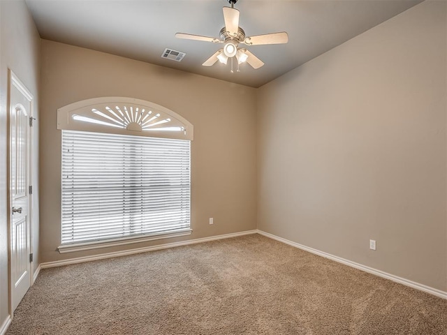 empty room featuring a ceiling fan, baseboards, visible vents, and carpet flooring