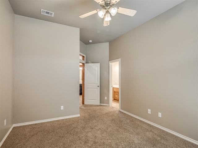 empty room with light carpet, a ceiling fan, visible vents, and baseboards