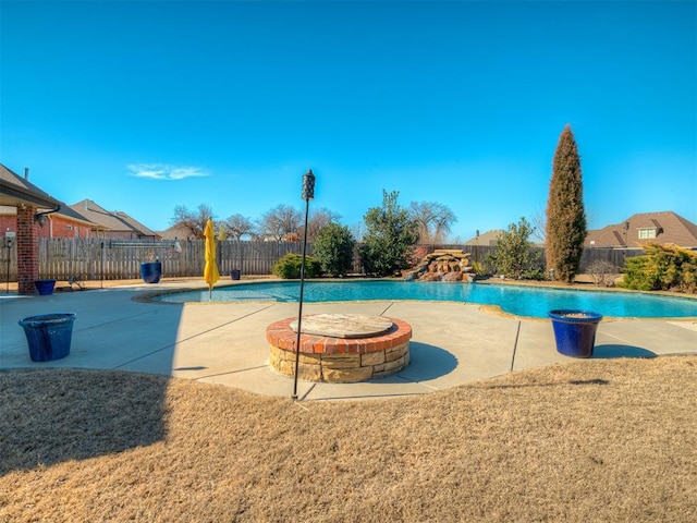 view of swimming pool featuring an outdoor fire pit, a patio area, a fenced backyard, and a fenced in pool