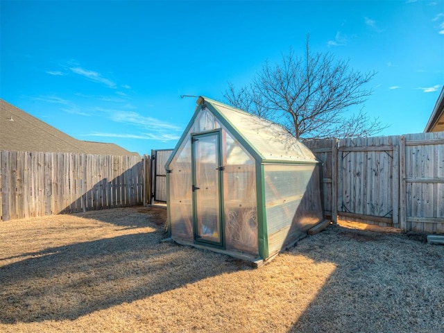 view of greenhouse featuring a yard and a fenced backyard