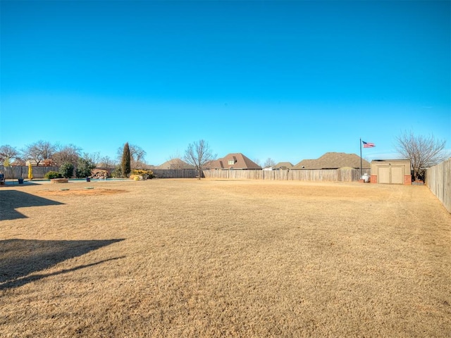 view of yard featuring a shed, fence, and an outdoor structure