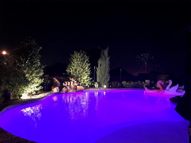 view of pool at night