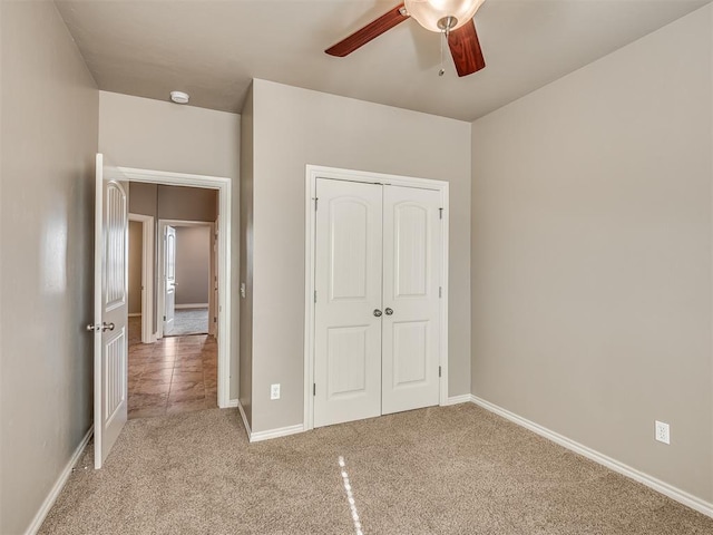 unfurnished bedroom with ceiling fan, a closet, and light carpet