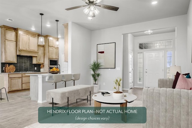 living room featuring ceiling fan, sink, and light hardwood / wood-style floors