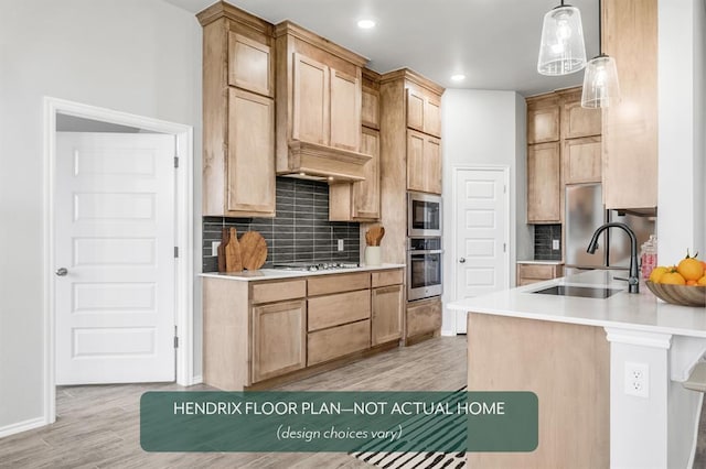 kitchen featuring pendant lighting, tasteful backsplash, sink, stainless steel appliances, and light wood-type flooring