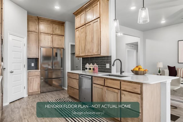 kitchen featuring stainless steel appliances, sink, backsplash, and light hardwood / wood-style floors