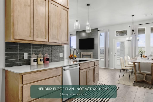 kitchen featuring tasteful backsplash, pendant lighting, sink, and stainless steel dishwasher