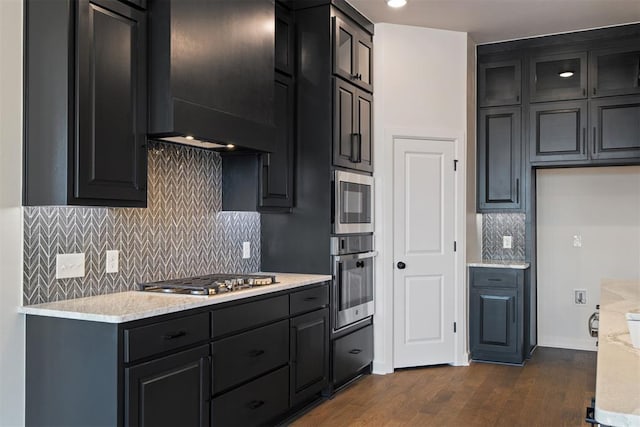 13325 SW 8th St, Yukon, OK 73099 - kitchen with decorative backsplash, baseboards, premium range hood, dark wood finished floors, and appliances with stainless steel finishes