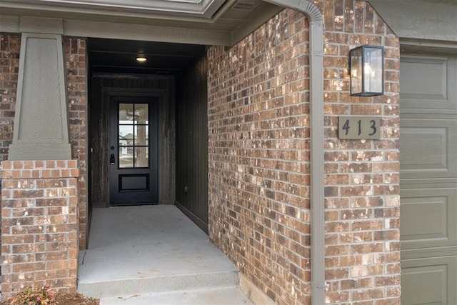 view of exterior entry featuring brick siding