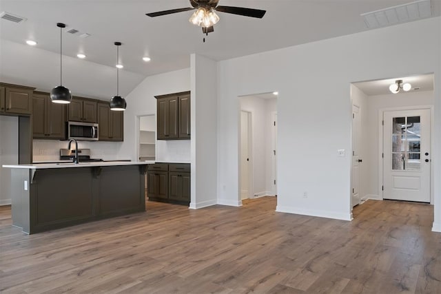 kitchen with stainless steel microwave, a ceiling fan, and visible vents