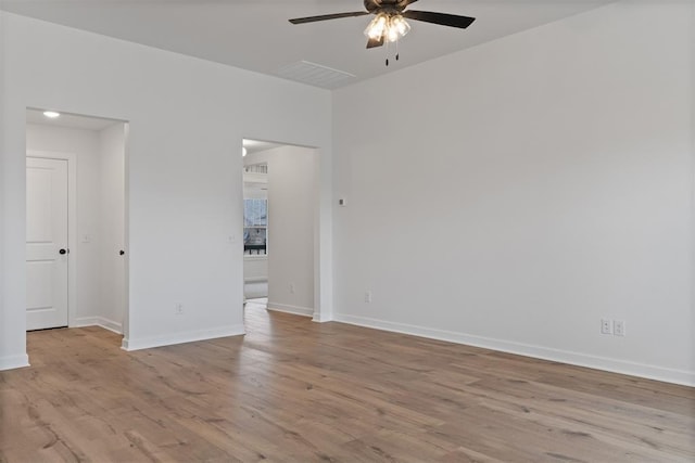spare room featuring baseboards, wood finished floors, and ceiling fan