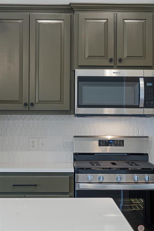 kitchen with tasteful backsplash, gray cabinetry, stainless steel appliances, and light countertops